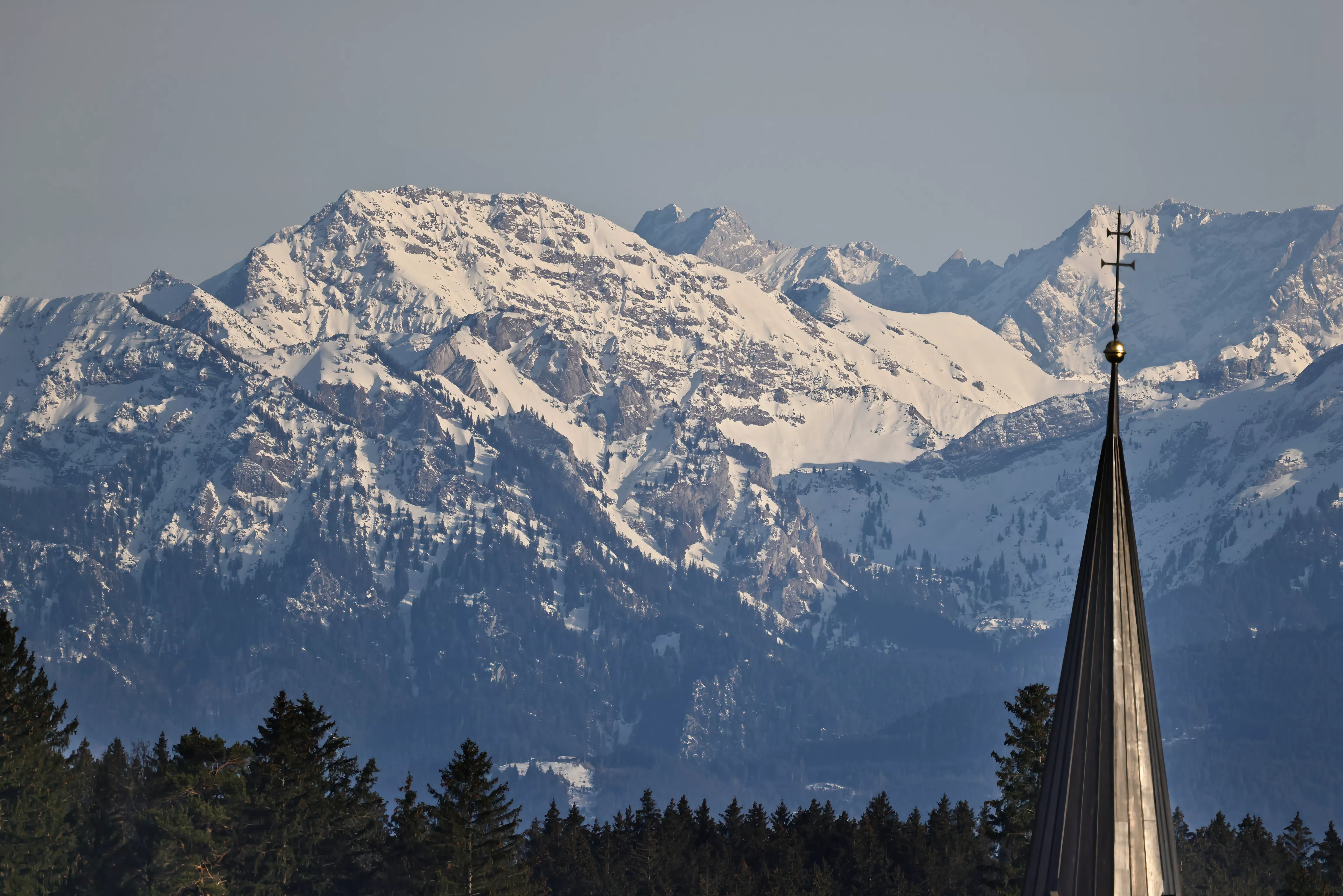Blick auf Aitrang mit typischer Allgäuer Architektur und umliegender Hügellandschaft.