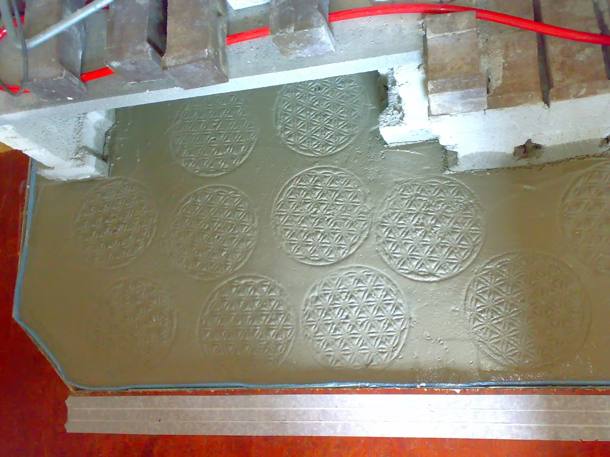 Blume des Lebens aus Edelstahl in den Estrich gedrückt 