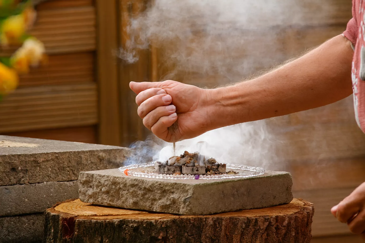 Rituelles Räuchern mit reichlich Räucherwerk umringt mit einer Bergkristall Kette.