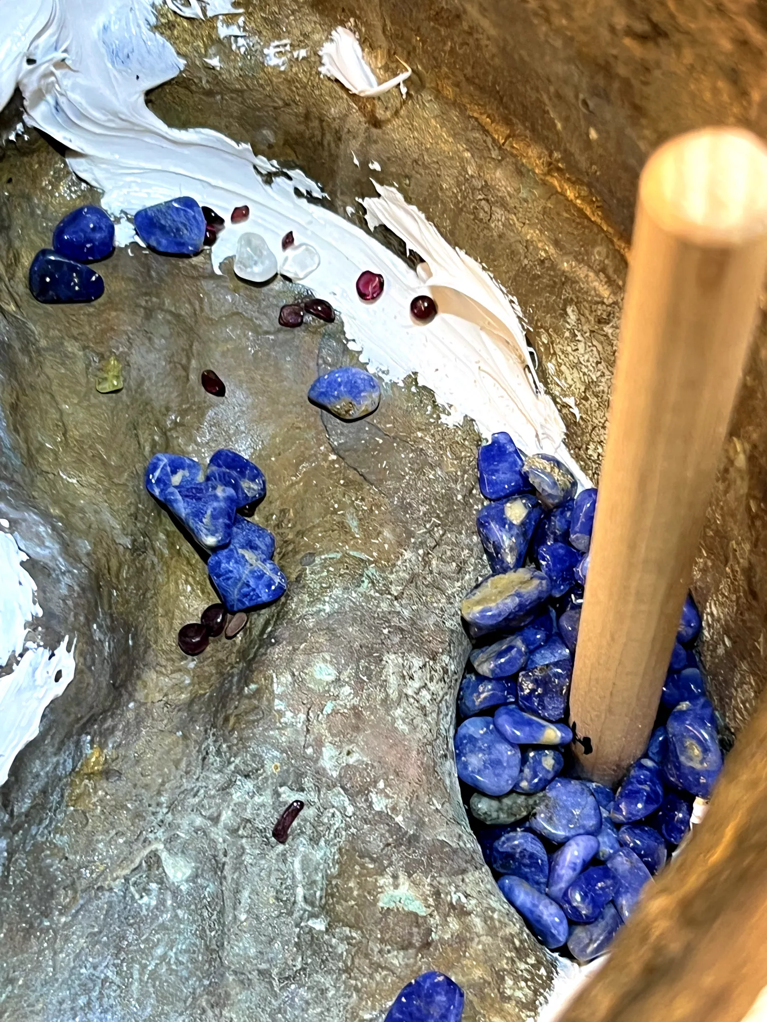 Nahaufnahme der Kristalle im Inneren der Tara‑Statue während der Füllung