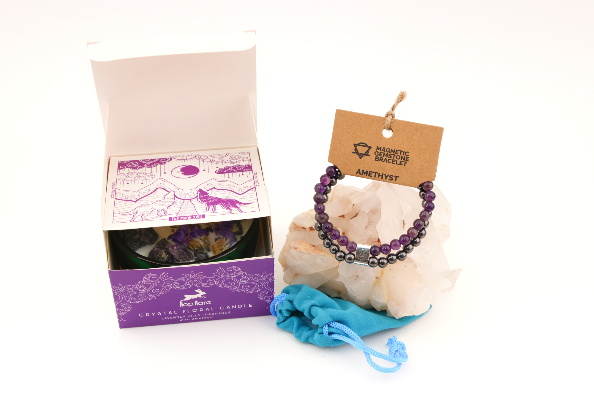 Grüne Hop‑Hare Duftkerze mit Citrin‑ und Amethyst‑Steinen sowie Blüten, daneben die lilafarbene Produktbox; rechts ein Amethyst‑Magnetarmband auf brauner Karte, präsentiert auf Bergkristallen mit türkisfarbenem Beutel.