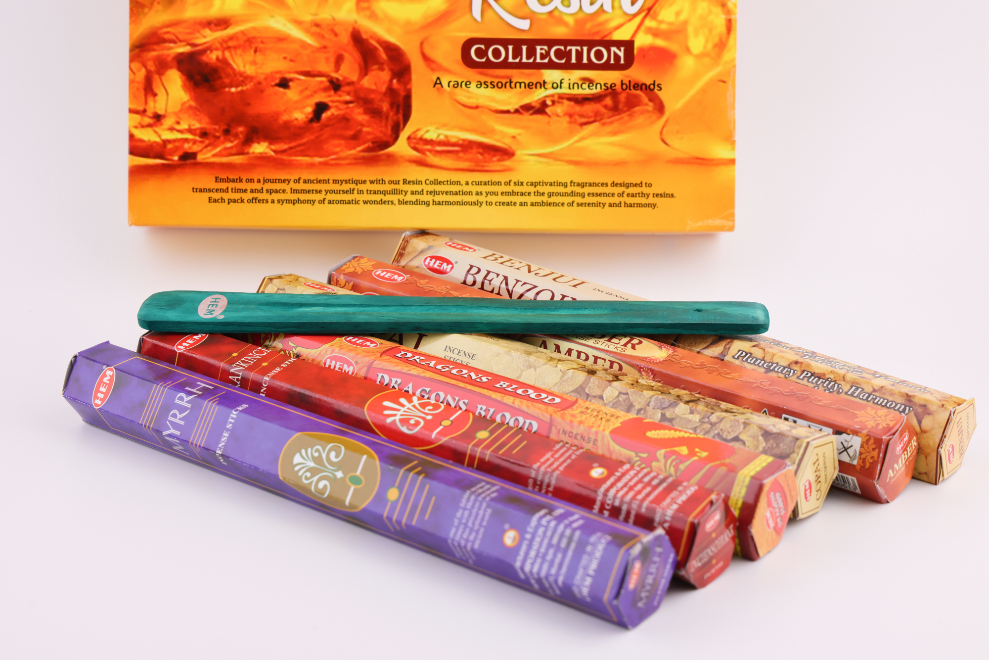 HEM Räucherwerk‑Set mit großer Resin Collection Box im Hintergrund sowie mehreren Duftstäbchen‑Packungen (Myrrh, Dragon’s Blood, Copal, Benzoin, Amber) und einem türkisfarbenen Räucherstäbchenhalter im Vordergrund.